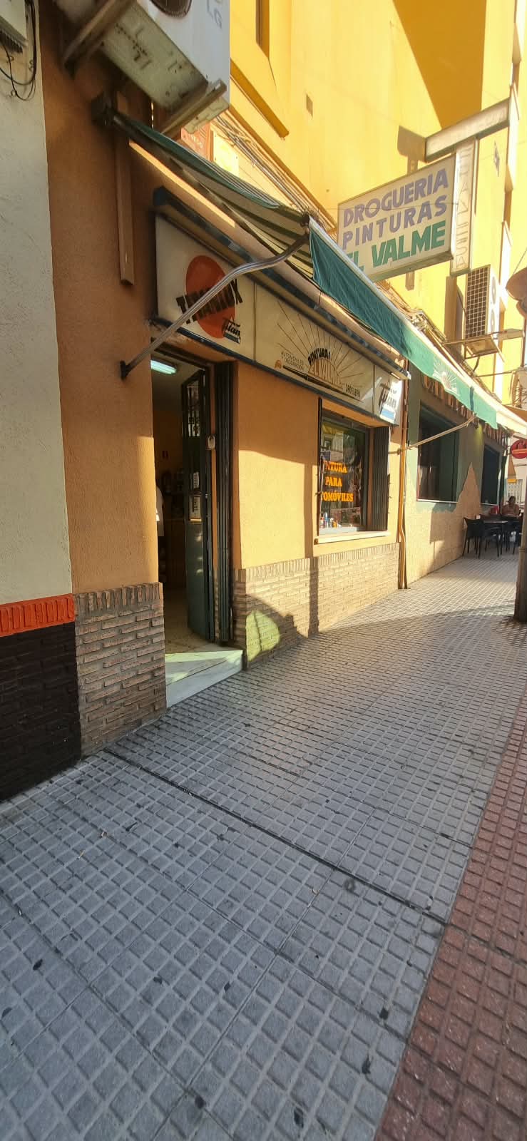 Fachada real de Pinturas El Valme, con su toldo verde y el rótulo de la tienda